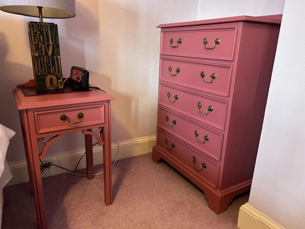 One tall check of drawers and one bedside table, painted in a dark pink